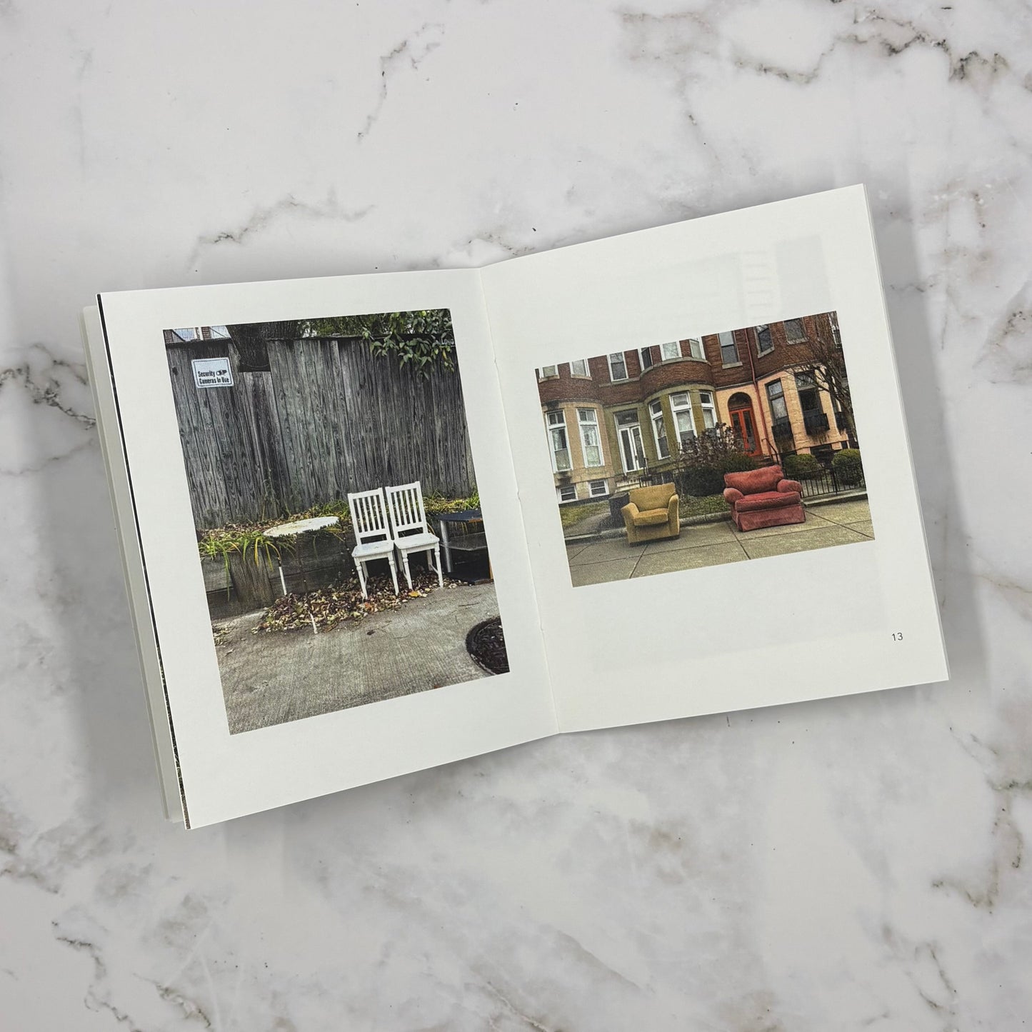Open mini photo book on a marble surface with two images of chairs in outdoor scenes