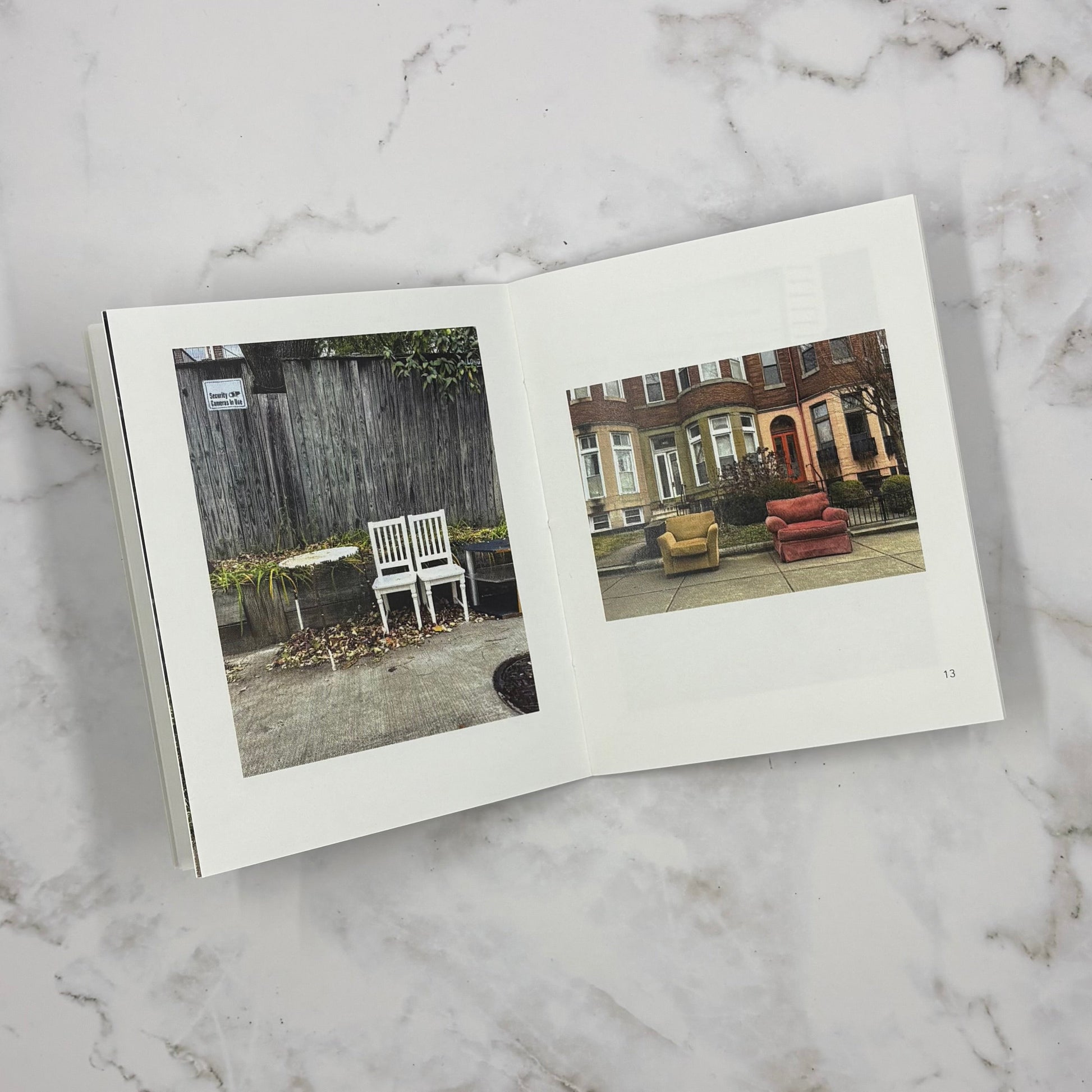 Open mini photo book on a marble surface with two images of chairs in outdoor scenes